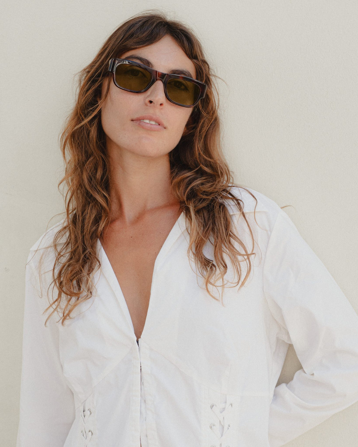 Woman wearing Massa amber tortoise wayfarer sunglasses with brown lenses and a white shirt
