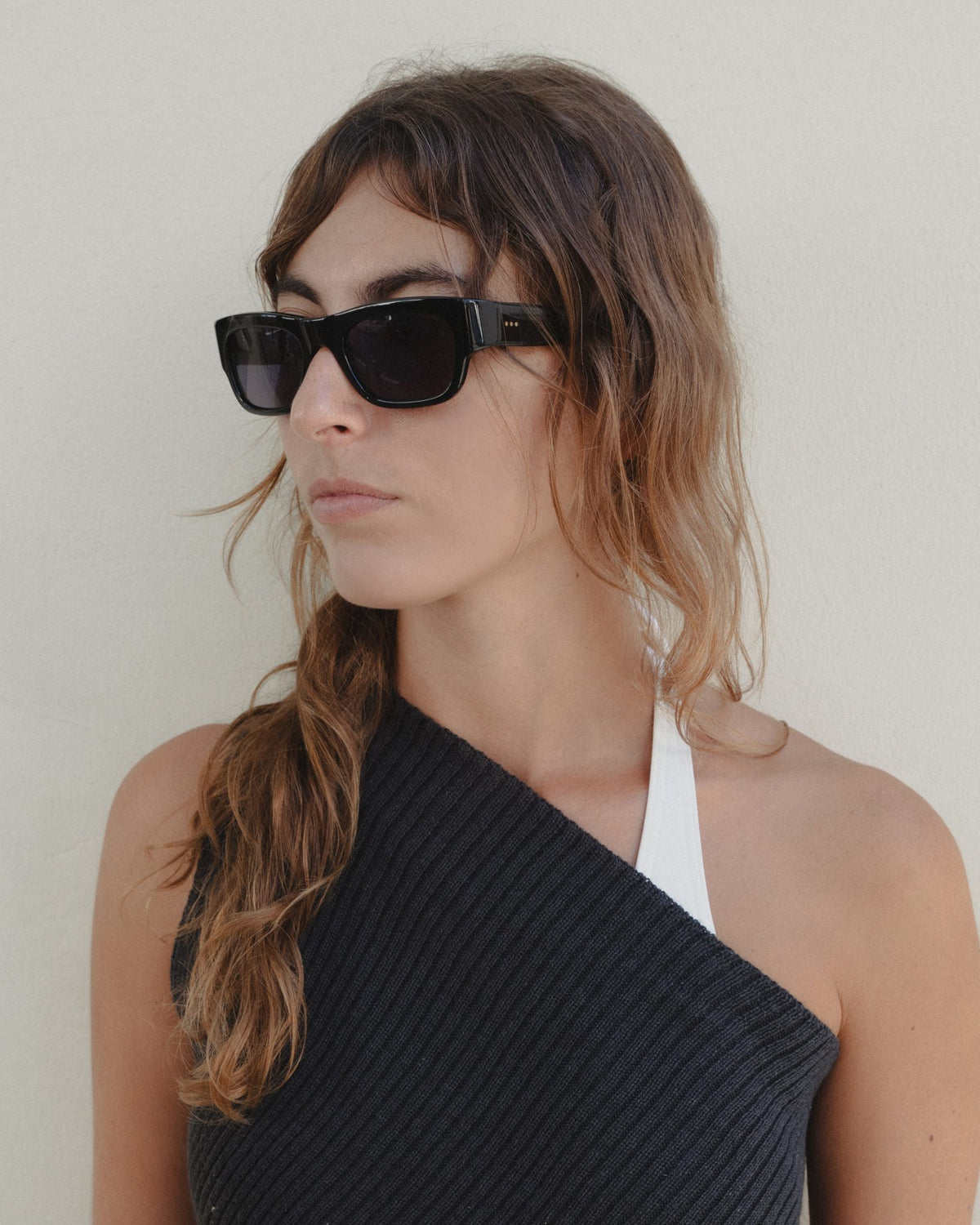 Woman wearing Massa black wayfarer sunglasses with black lenses, three-quarter view