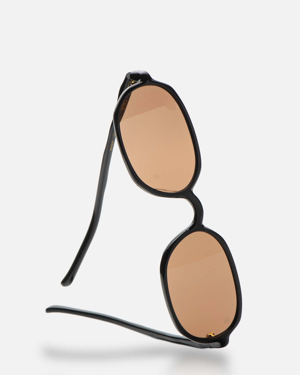 Seda black 90s oval sunglasses with brown lenses, angled view