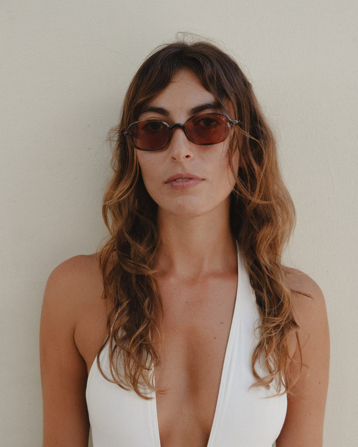 Woman wearing Seda tortoise 90s oval sunglasses with brown lenses, close-up