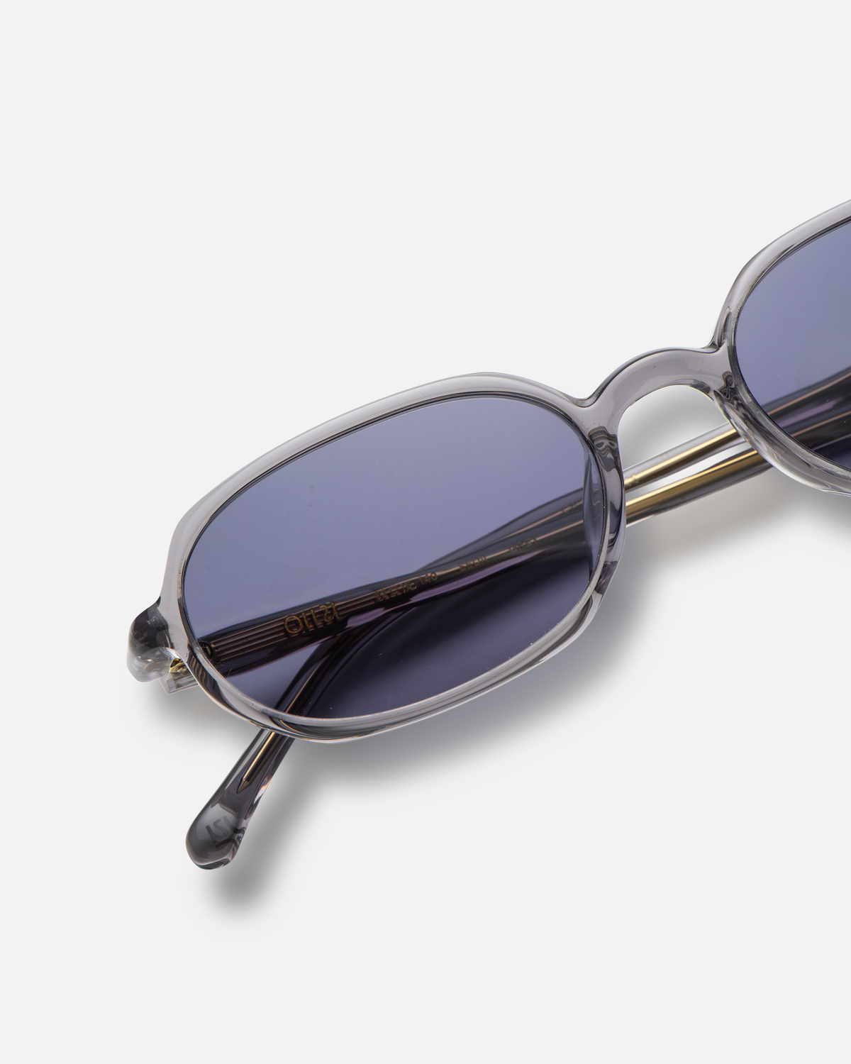 Seda gray 90s oval sunglasses with dark purple lenses, angled view