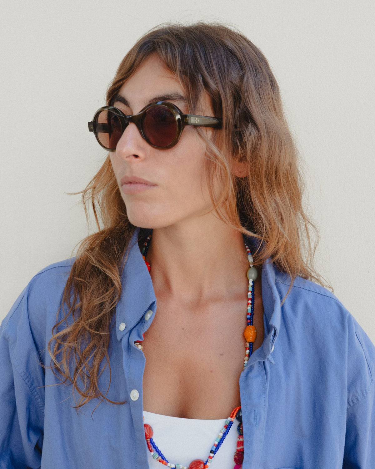 Woman wearing Umi brown round sunglasses with brown lenses, side view