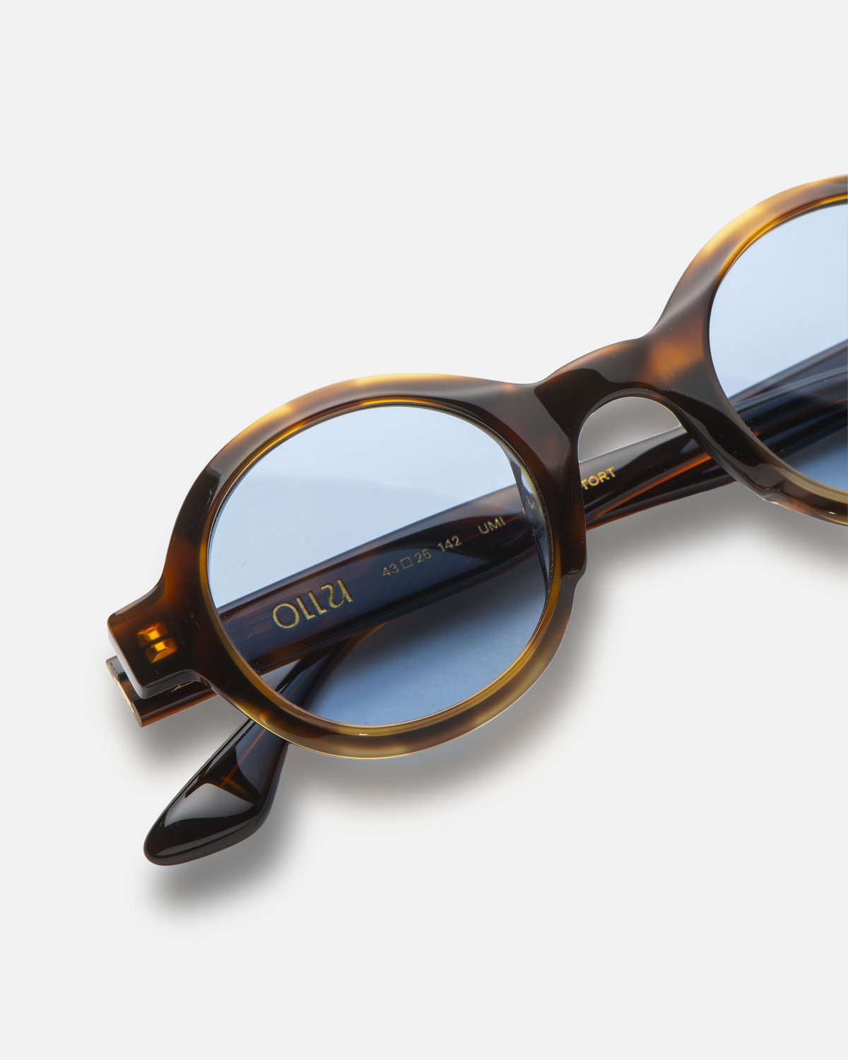 Umi tortoise narrow round sunglasses with blue lenses, angled view