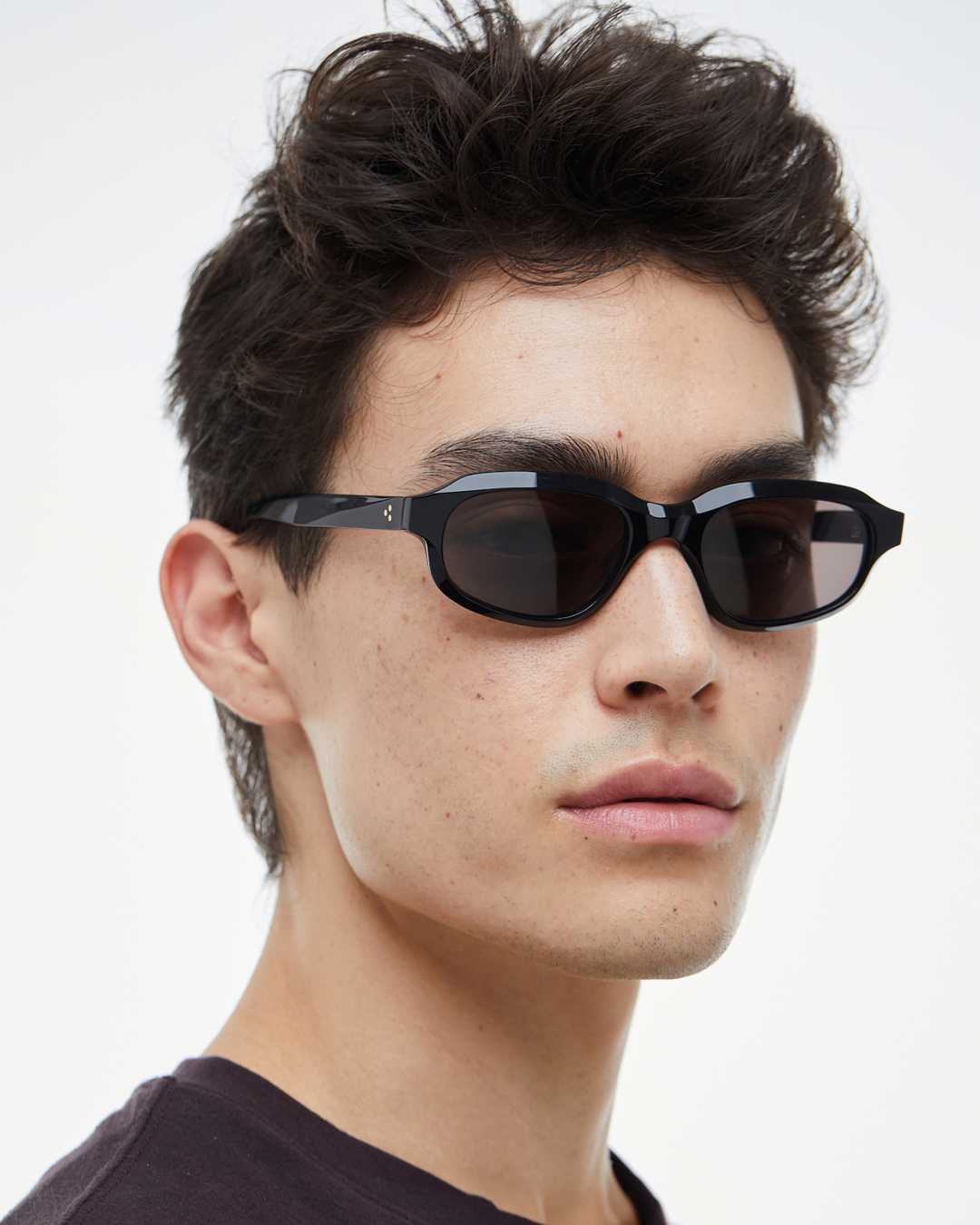 Man wearing Agaté black oval cat-eye sunglasses with black lenses, look 2