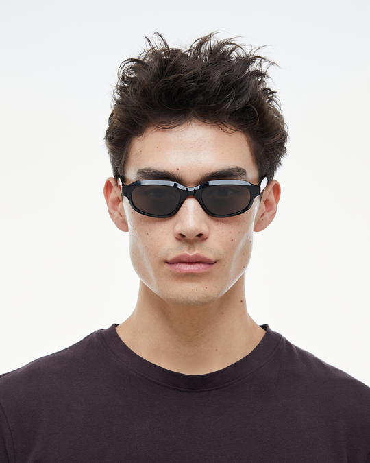 Man wearing Agaté black oval cat-eye sunglasses with black lenses