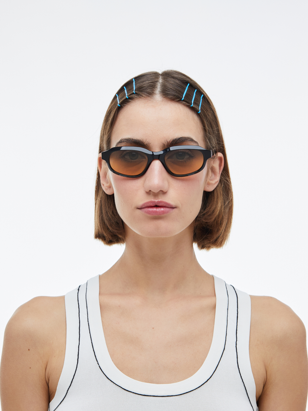 Woman wearing Agaté black oval cat-eye sunglasses with gradient orange-to-blue lenses