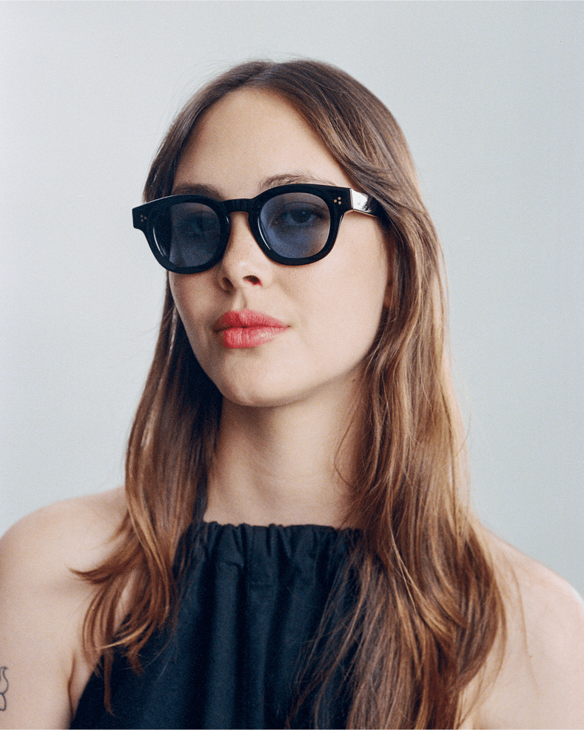Woman wearing Coco black round sunglasses with light blue lenses, look 2