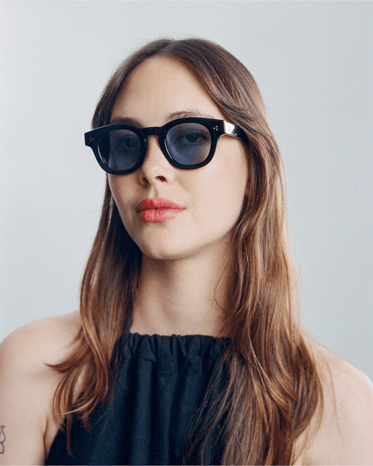 Woman wearing Coco black round sunglasses with light blue lenses, look 2