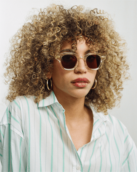 Woman wearing Coco clear round sunglasses with brown lenses