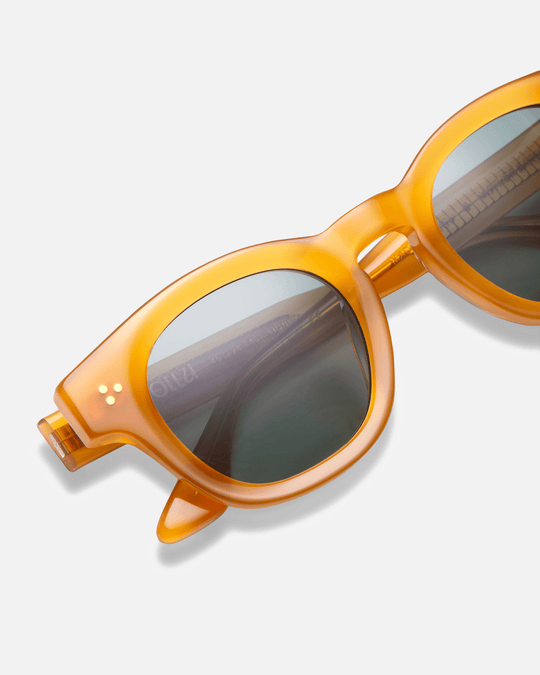 Coco honey yellow round sunglasses with green lenses, angled view