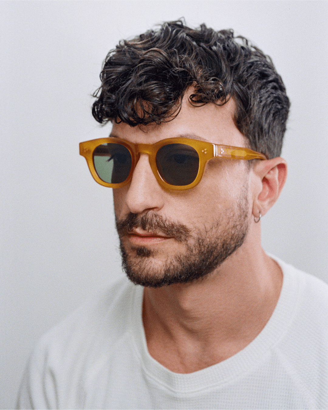 Man wearing Coco honey yellow round sunglasses with green lenses