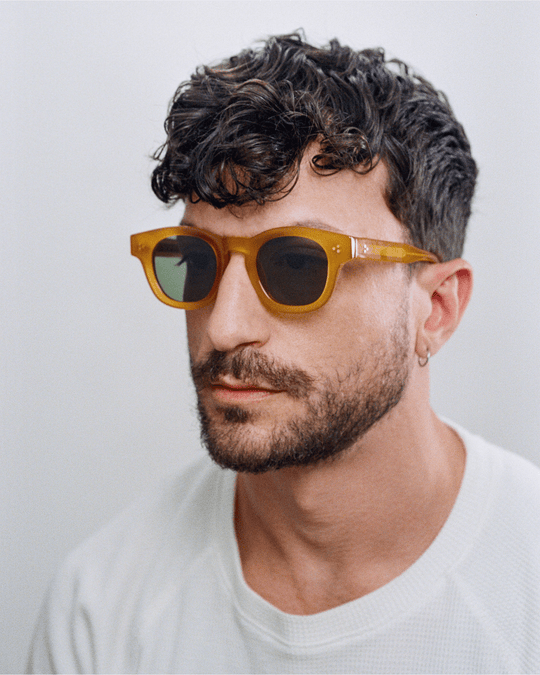 Man wearing Coco honey yellow round sunglasses with green lenses