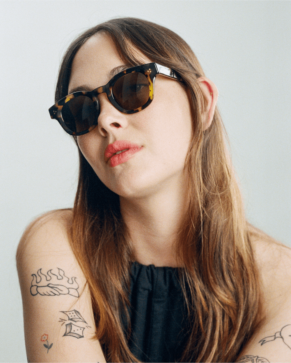 Woman wearing Coco tortoise round sunglasses with green lenses