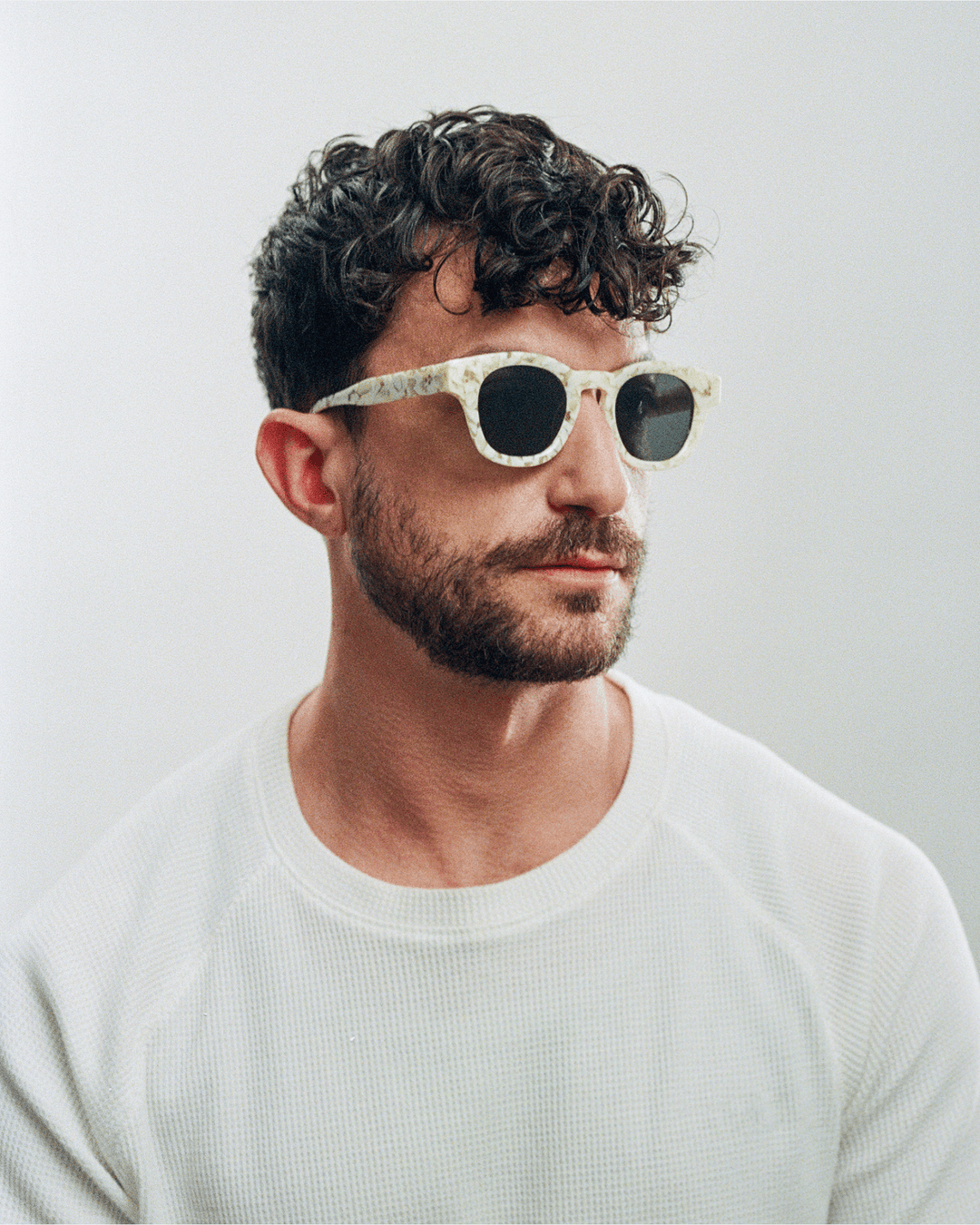 Man wearing Coco white tortoise round sunglasses with green lenses