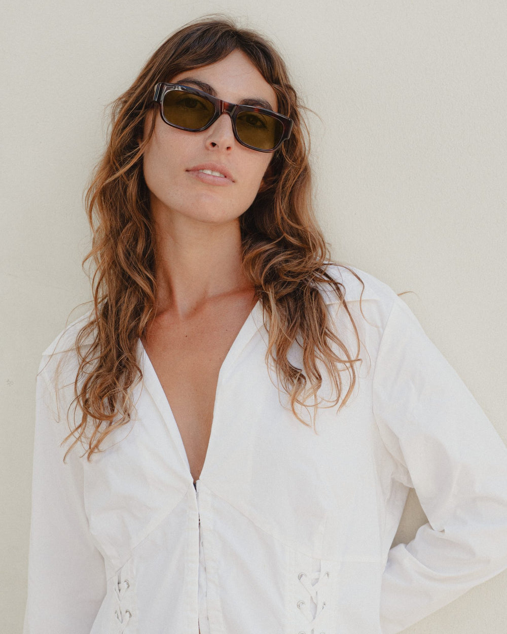 Woman wearing Massa amber tortoise wayfarer sunglasses with brown lenses and a white shirt
