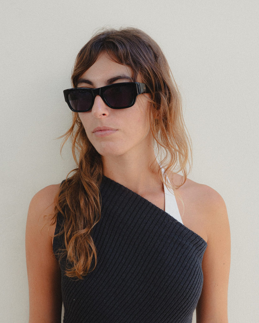 Woman wearing Massa black wayfarer sunglasses with black lenses, close-up