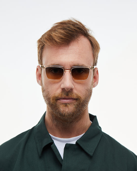 Man wearing Pepino clear rectangle sunglasses with gradient orange-to-blue lenses, look 5