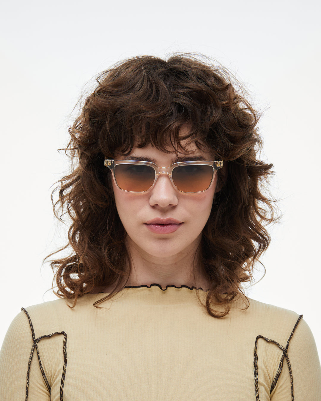 Woman wearing Pepino clear rectangle sunglasses with gradient orange-to-blue lenses