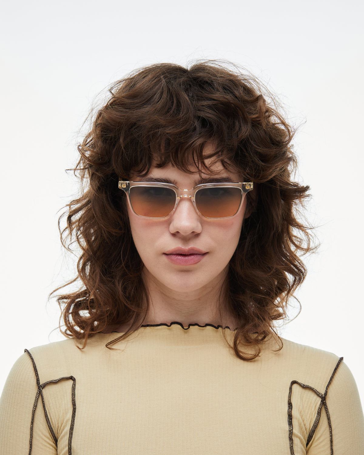 Woman wearing Pepino clear rectangle sunglasses with gradient orange-to-blue lenses