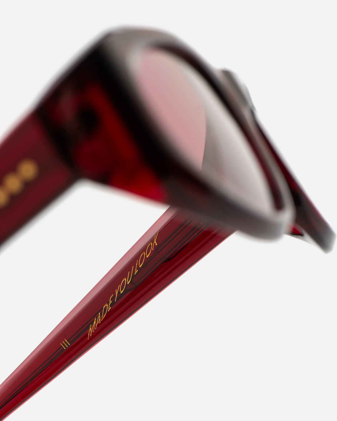 Pomé burgundy oval wrap sunglasses with red lenses, angled view