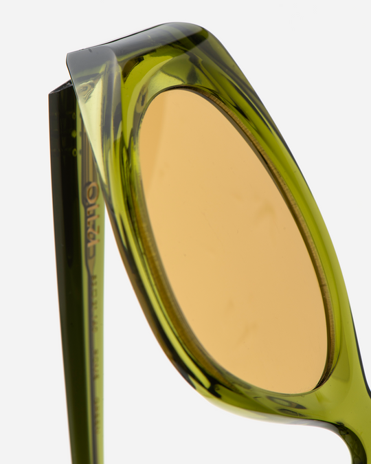 Pomé green oval wrap sunglasses with yellow lenses, angled view