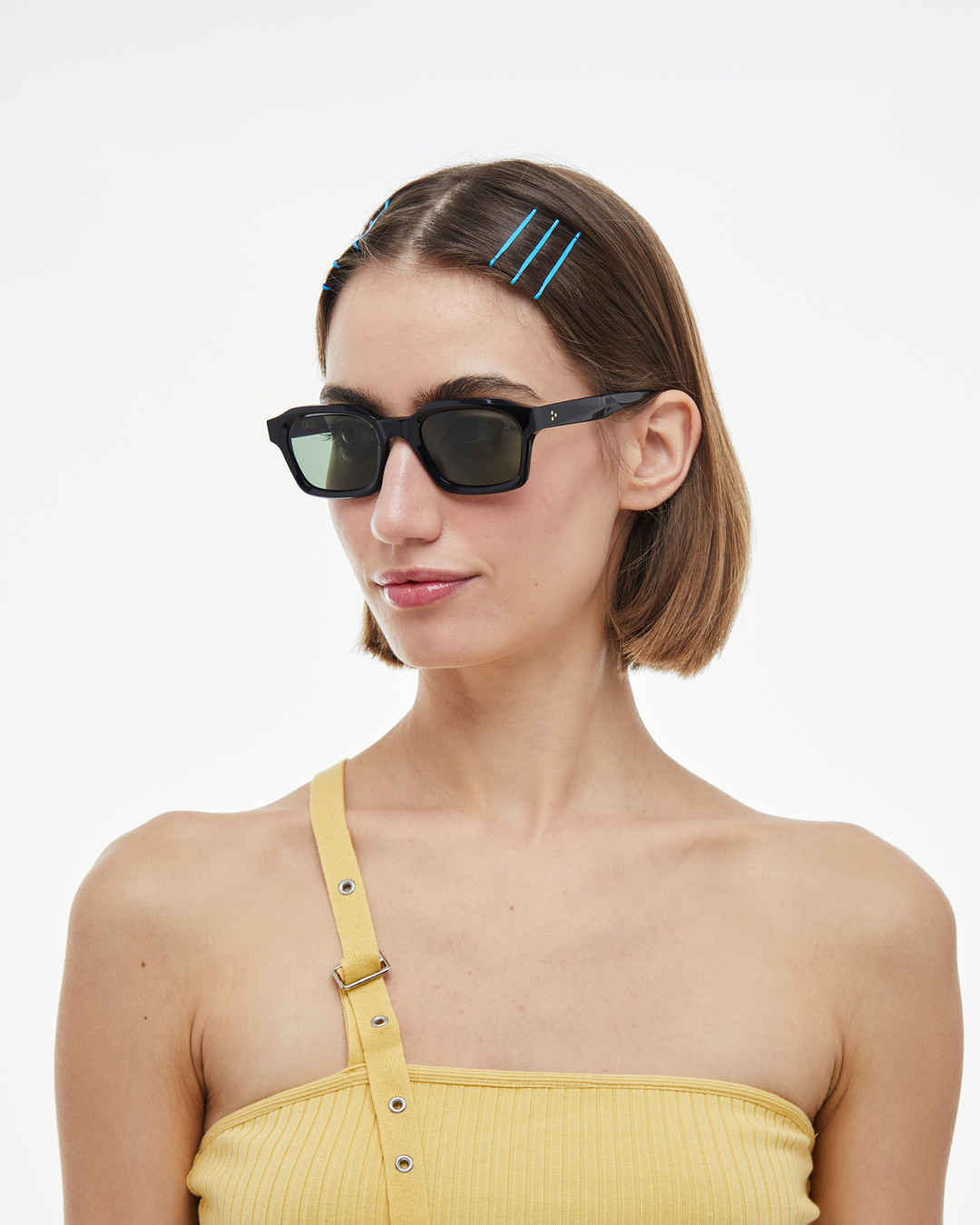 Woman wearing Saguaro black square sunglasses with green lenses, look 2