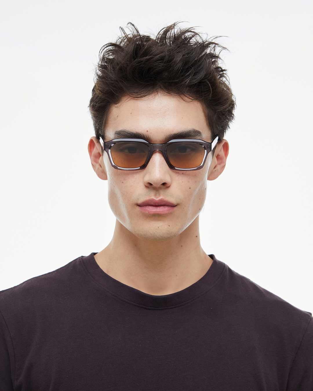 Man wearing Saguaro gray square sunglasses with gradient orange-to-blue lenses