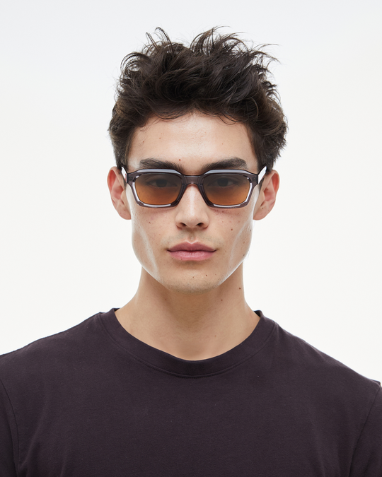 Man wearing Saguaro gray square sunglasses with gradient orange-to-blue lenses