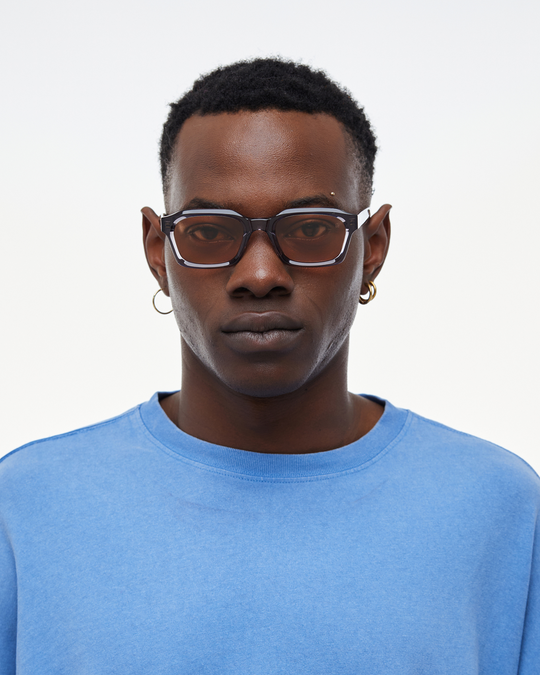 Man wearing Saguaro gray square sunglasses with orange lenses