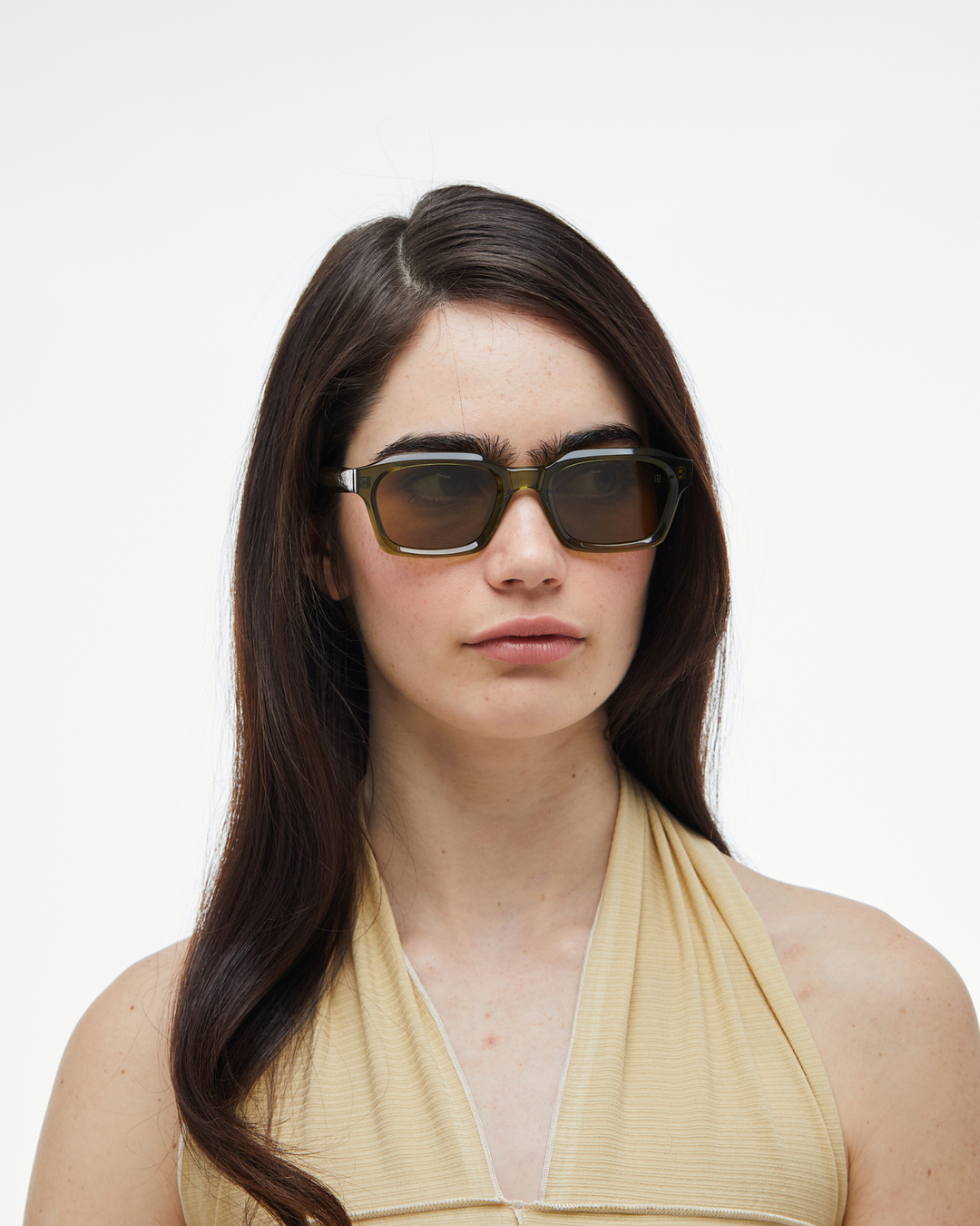 Woman wearing Saguaro green square sunglasses with brown lenses, look 2