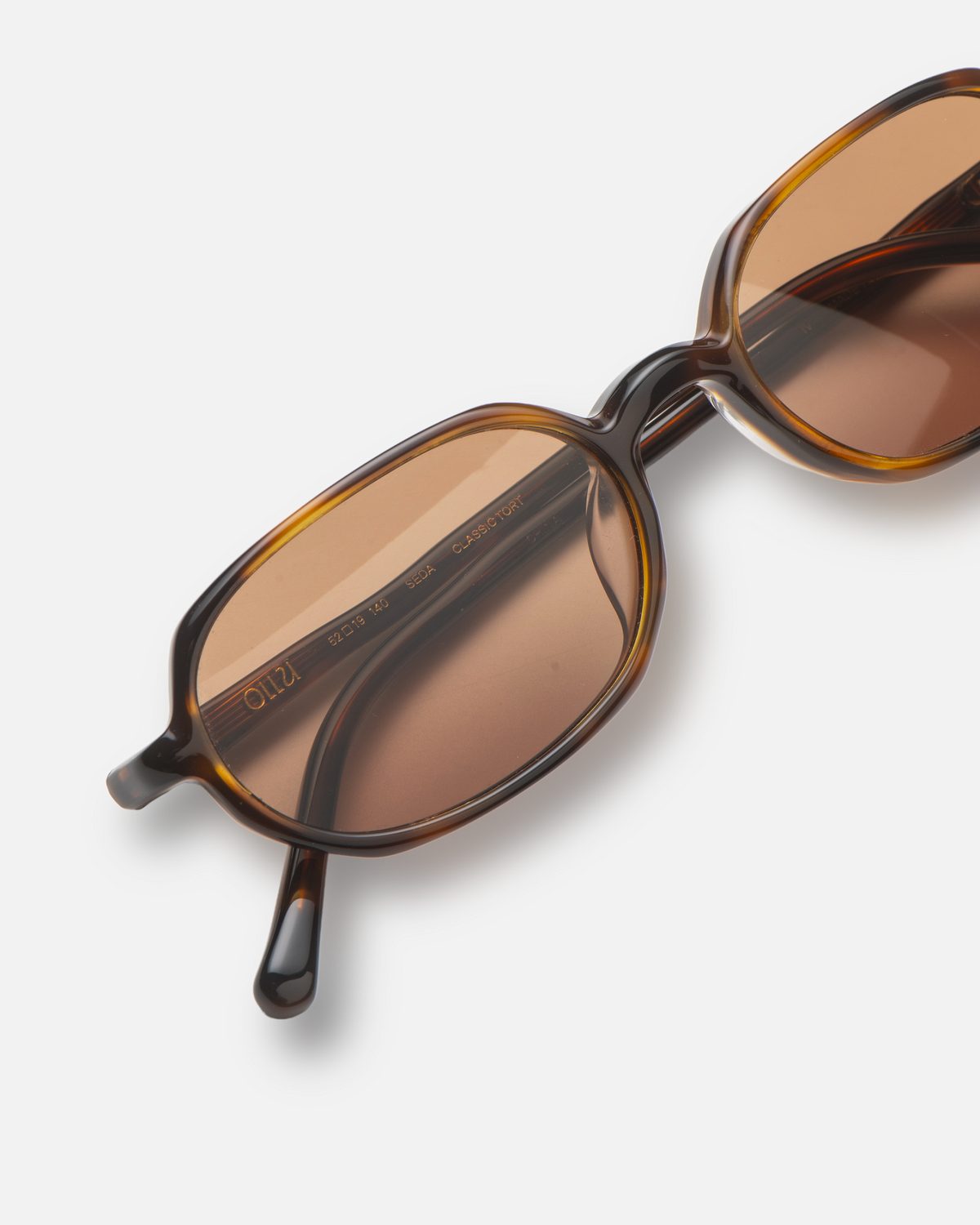 Seda brown 90s oval sunglasses with brown lenses, angled view