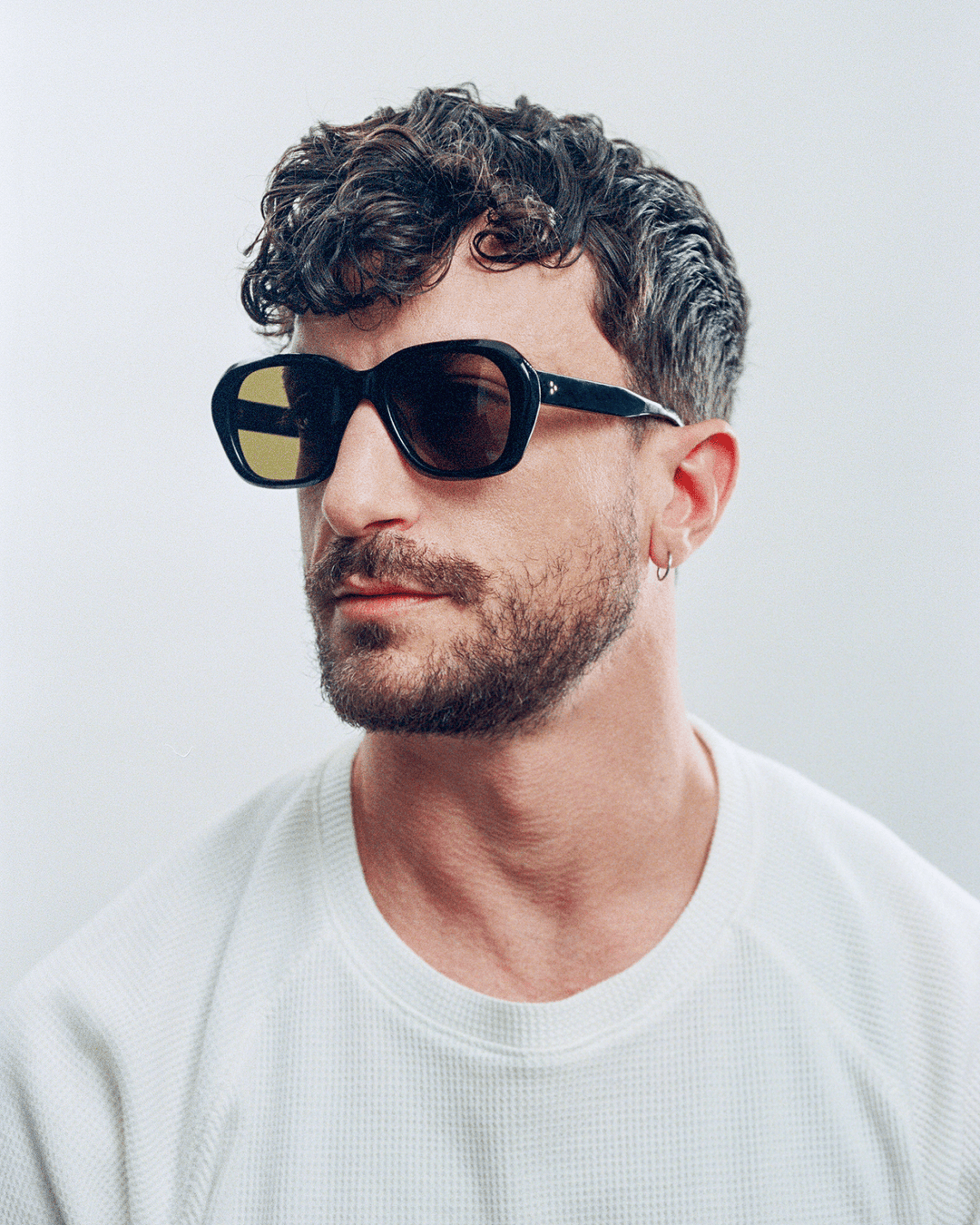 Man wearing Tamar black round sunglasses with brown lenses