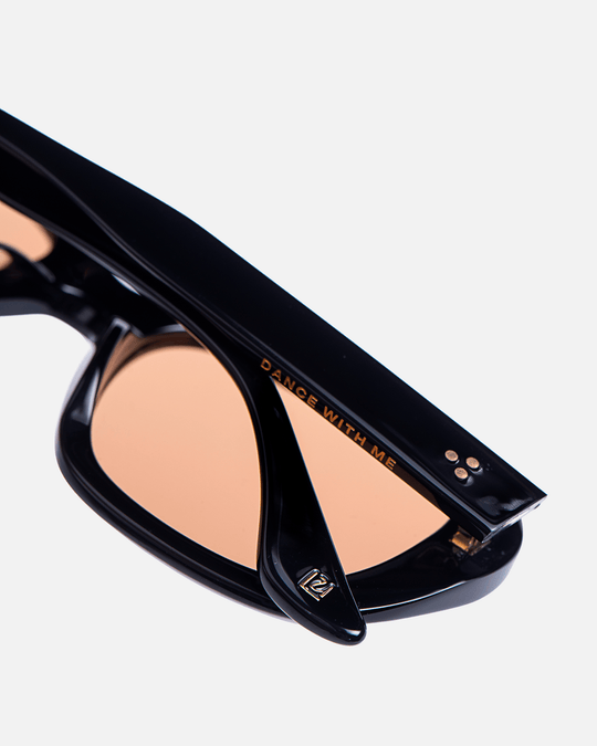 Tamar black round sunglasses with orange lenses, angled view