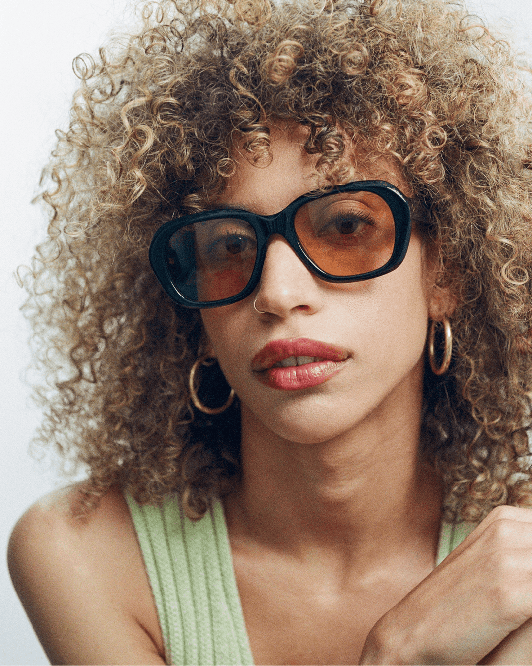 Woman wearing Tamar black round sunglasses with orange lenses, look 2