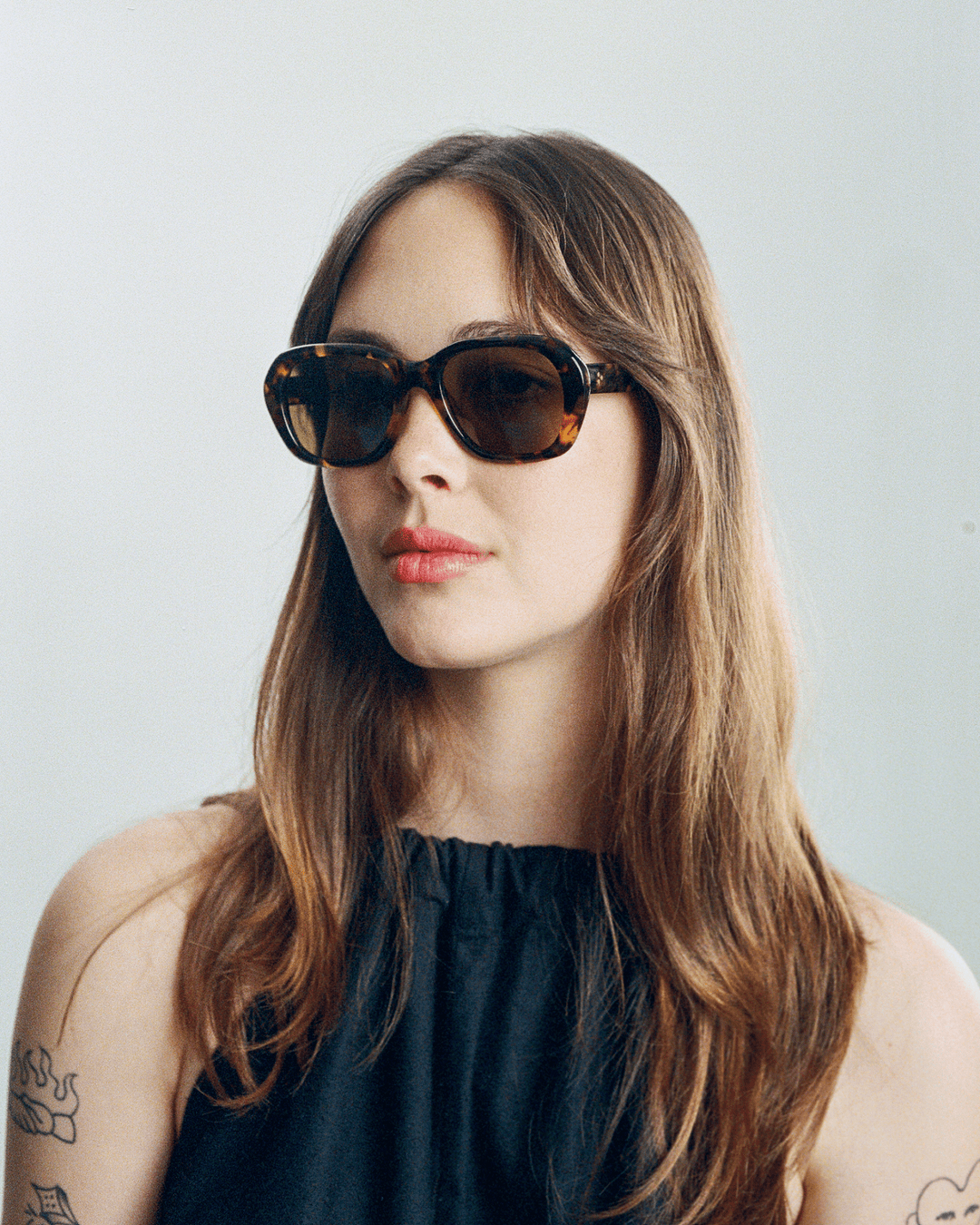 Woman wearing Tamar dark tortoise round sunglasses with brown lenses