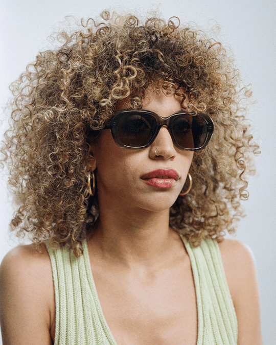 Woman wearing Tamar green round sunglasses with brown lenses