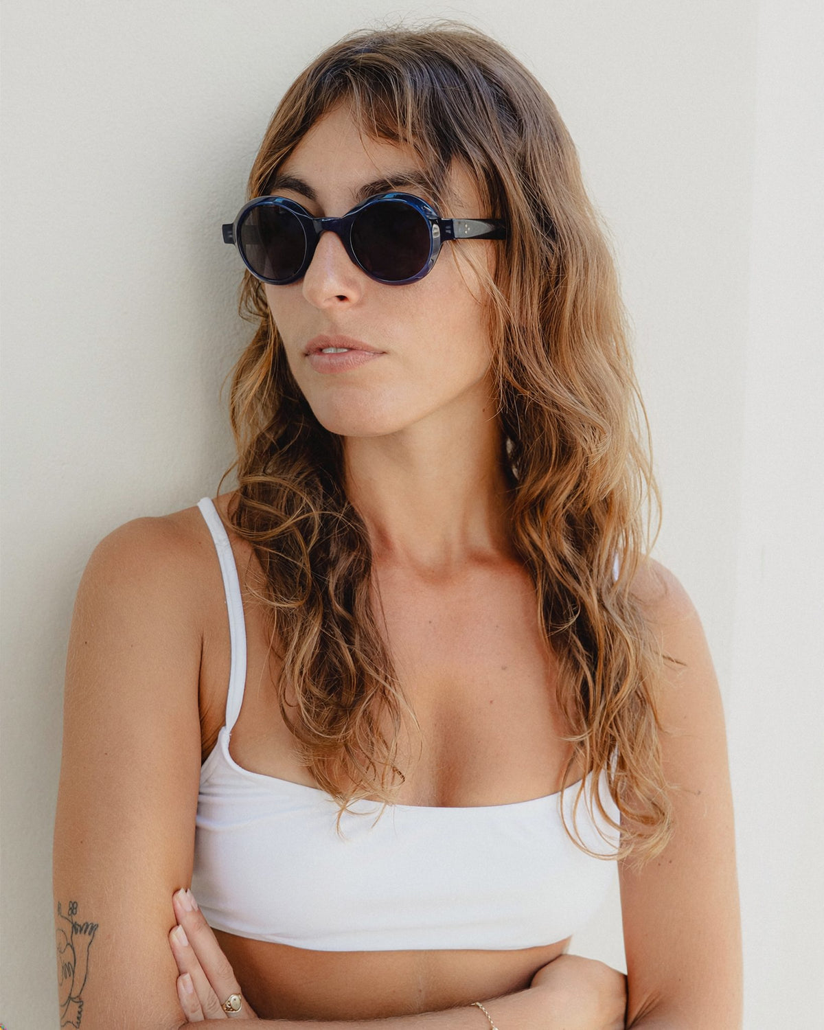 Woman wearing Umi navy round sunglasses, three-quarter view