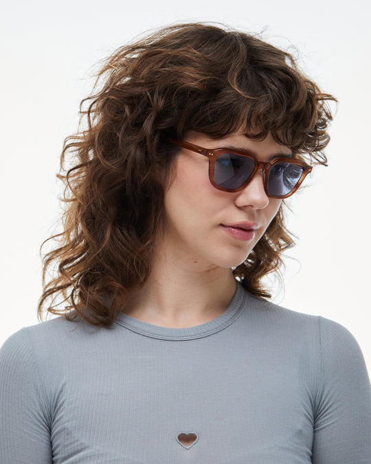 Woman wearing Yuzu light brown rounded square sunglasses with light blue lenses, look 2