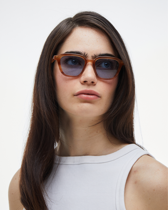 Woman wearing Yuzu light brown rounded square sunglasses with light blue lenses